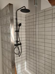 a shower in a bathroom with white tiled walls at Aloxamento A Mariña in Oia
