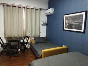 a room with a bed and a table with a chair at Residencial Praia do Flamengo - Zona Sul Rio de Janeiro in Rio de Janeiro