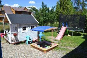 a playground with a play house and a slide at PERŁA in Białka Tatrzańska