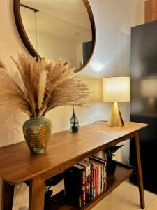 a vase on a table with a mirror and a lamp at High Flyer KLIA at Alanis Residence Kota Warisan in Sepang