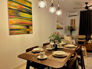 a dining room table with chairs and a painting on the wall at High Flyer KLIA at Alanis Residence Kota Warisan in Sepang