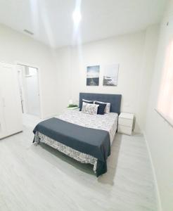 a bedroom with a bed in a white room at Apartamento Plaza Calzada 1 in Sanlúcar de Barrameda