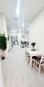 a large white room with a table and chairs at Apartamento Plaza Calzada 1 in Sanlúcar de Barrameda