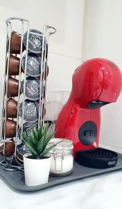 a red mixer sitting on a tray with a plant at Apartamento Plaza Calzada 1 in Sanlúcar de Barrameda +8 photos