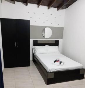 een slaapkamer met een bed en een zwarte kast bij APARTESTUDIO ALCALA ENVIGADO, CERCA A C.C VIVA . in Envigado