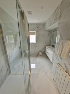 een badkamer met een douche, een bad en een wastafel bij Buncrana Beach House by Wild Atlantic Wanderer in Buncrana