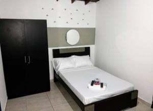een kleine slaapkamer met een bed en een spiegel bij APARTESTUDIO ALCALA ENVIGADO, CERCA A C.C VIVA . in Envigado