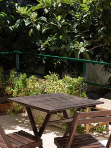 a wooden picnic table and benches in front of trees at A casa di Nonna Rosa in Lecce