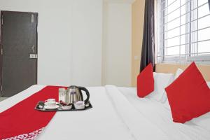 a hotel room with a bed with a tray with teaiments on it at Super OYO Flagship Sapphire Homes Stay in Hinjewadi
