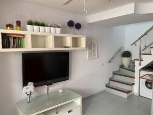 a living room with a tv and a staircase at Bungalow Maspalomas in Maspalomas