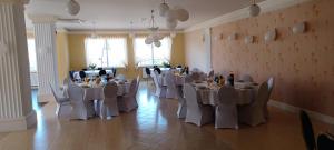 a banquet hall with white tables and chairs at Dom Gościnny Liść Dębu 