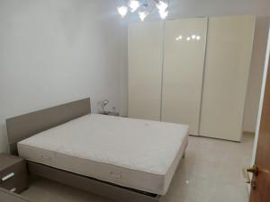 ein weißes Schlafzimmer mit einem Bett und einem Schrank in der Unterkunft VILLA PARADISO TAVERNETTA in Scanzano