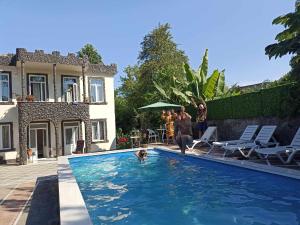 a man and a dog in a swimming pool at Green Garden in Batumi
