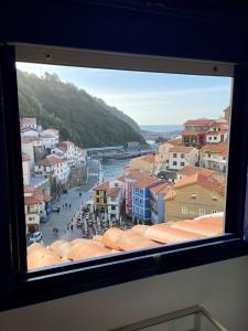 una ventana con vistas a una ciudad con un río en Casa de pescadores con vistas al mar, en Cudillero