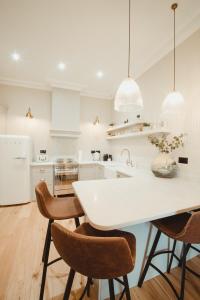 cocina blanca con mesa blanca y sillas en ch1 boutique stays, en Chester