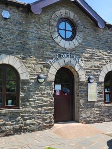 纽比桥莱克兰一田一墅酒店的石头建筑,有门和标志
