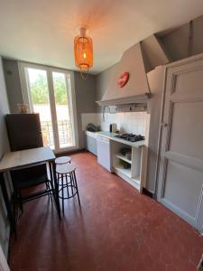 eine Küche mit einem Tisch, Stühlen und einem Herd in der Unterkunft BEAU T2 BOMPARD ENDOUME in Marseille