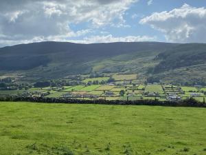 a green field with mountains in the background at Slieve Gullion Valley View in Camlough