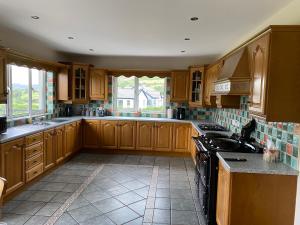 a kitchen with wooden cabinets and a stove top oven at Slieve Gullion Valley View in Camlough +14 photos