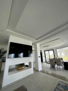 a living room with a large television and chairs at Villa Marina Hills - Tamuda Bay in Jebel Zemzem