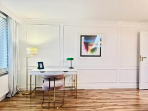a white room with a desk and a chair at Apartament pod Kasztanem in Lębork +6 photos