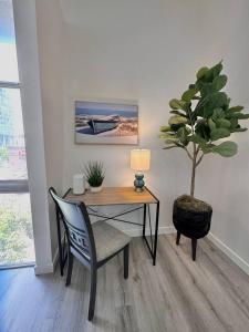 a desk with a chair and a potted tree in a room at Luxurious Condo Walking Distance to San Diego Bay! in San Diego