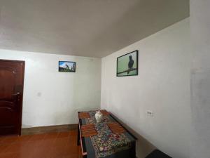 een kamer met een tafel en twee foto's aan de muur bij Hermoso departamento en el corazón de Papallacta in Papallacta