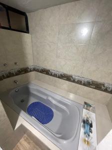 a bath tub in a bathroom with a blue lid at Hermoso departamento en el corazón de Papallacta in Papallacta +11 photos