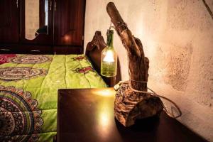 a bottle of wine on a table next to a bed at Hermoso departamento en el corazón de Papallacta in Papallacta