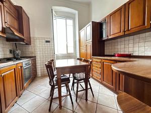 una cucina con mobili in legno e un tavolo con sedie di La Via Sul Mare a Bordighera