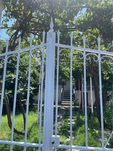 a white fence in front of a house at Ideal Cottage Holidays-Ιδανικές Εξοχικές Διακοπές in Áyioi Apóstoloi