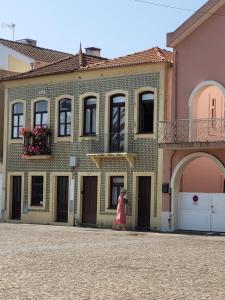 Casa da Varina في توريرا: فتاة صغيرة تمشي أمام مبنى