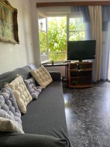 a living room with a couch and a flat screen tv at Ideal Cottage Holidays-Ιδανικές Εξοχικές Διακοπές in Áyioi Apóstoloi