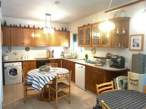 a kitchen with wooden cabinets and a table with chairs at Konnos Villa in Protaras