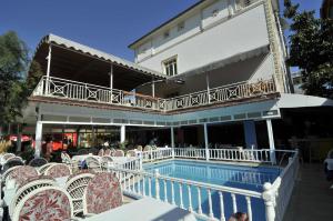 a group of chairs and a pool in front of a building at Sun Kiss Hotel in Side