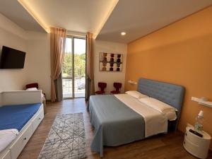 1 dormitorio con 1 cama y TV en la pared en La Casa di Matilde, en Barcellona-Pozzo di Gotto