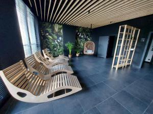 3 bancos de madera en una habitación con plantas en Parkcity Sokolska en Katowice