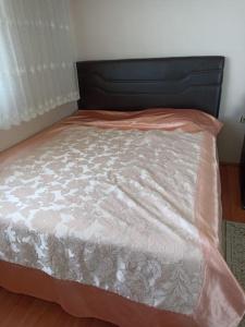 Una cama con un edredón rosa y blanco. en Deniz ve Doğa Manzaralı, en Fındıklı