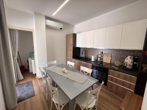 cocina y comedor con mesa y sillas en La Casa di Matilde, en Barcellona-Pozzo di Gotto