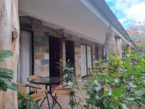 a patio with chairs and a table and some plants at Hostal Avareipua in Hanga Roa