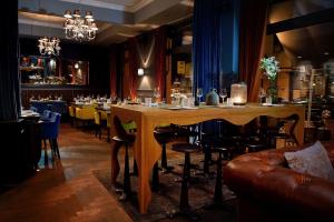 a bar with a large wooden table and chairs at Syte Boutique Hotel Mannheim in Mannheim
