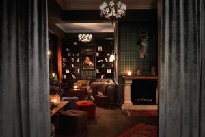 a living room with a fireplace and a chandelier at Syte Boutique Hotel Mannheim in Mannheim