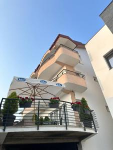 a building with potted plants and an umbrella on a balcony at Villa Stefanoski in Konsko