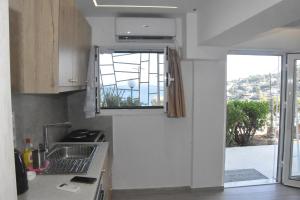 a kitchen with a sink and a window at MNS Marvelous Nirvana Seascape, Creativity in Panayía