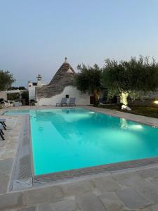 a large swimming pool in front of a house at Trulli di una volta in Alberobello