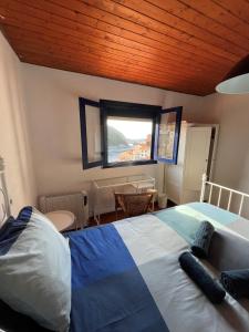 a bedroom with a large bed and a window at Casa de pescadores con vistas al mar in Cudillero