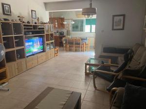 a living room with a couch and a tv and a table at Konnos Villa in Protaras
