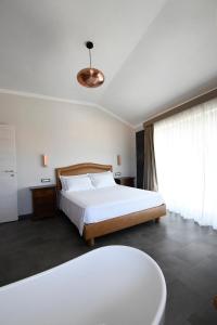 ein Schlafzimmer mit einem Bett und einem großen Fenster in der Unterkunft THE APARTMENT Top Floor in Tivoli