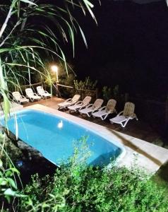a swimming pool at night with lounge chairs and a pool at Moradillo Apart in La Cuesta