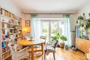 a dining room with a table and chairs and bookshelves at MARONA - Home Studio - where Music and Art meet Business in Perchtoldsdorf